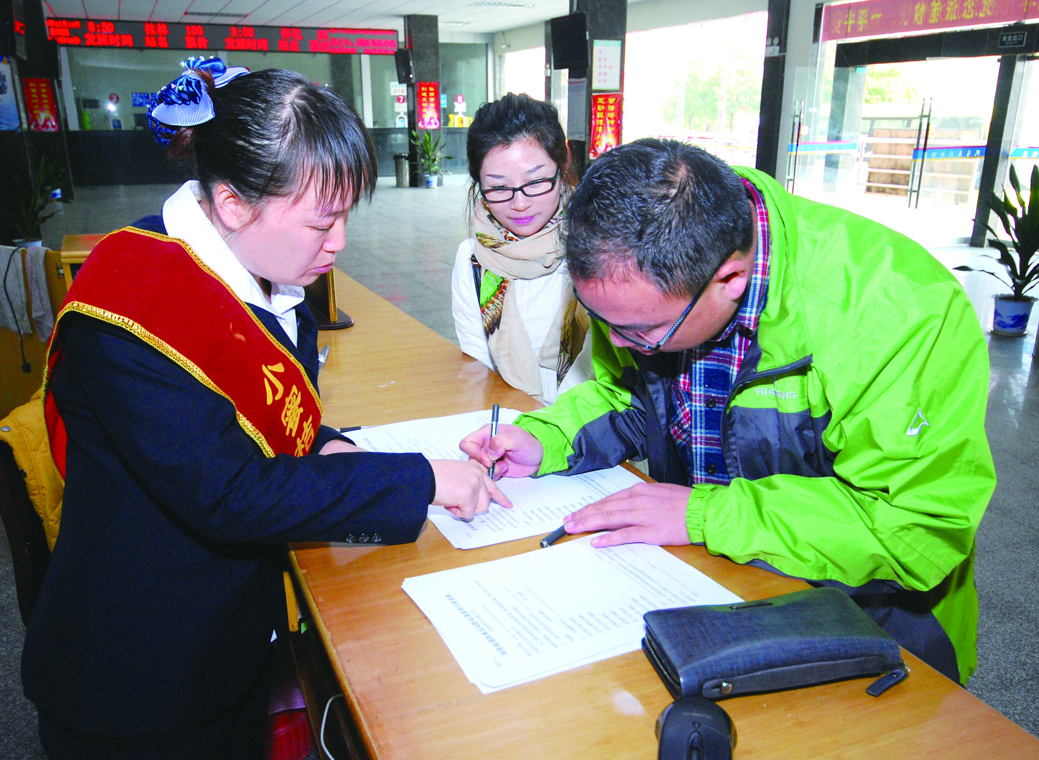 圖為洞口汽車總站站務(wù)人員在熱心為旅客服務(wù)。